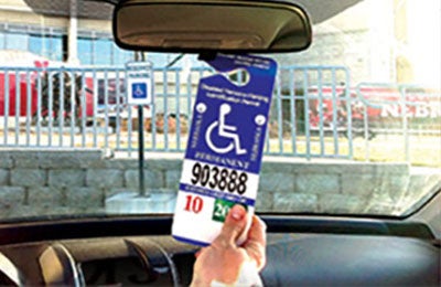 handicap permit hanging on rear-view mirror inside vehicle