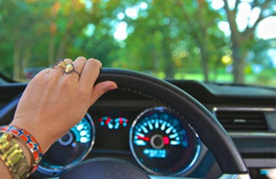 hand on steering wheel driving vehicle