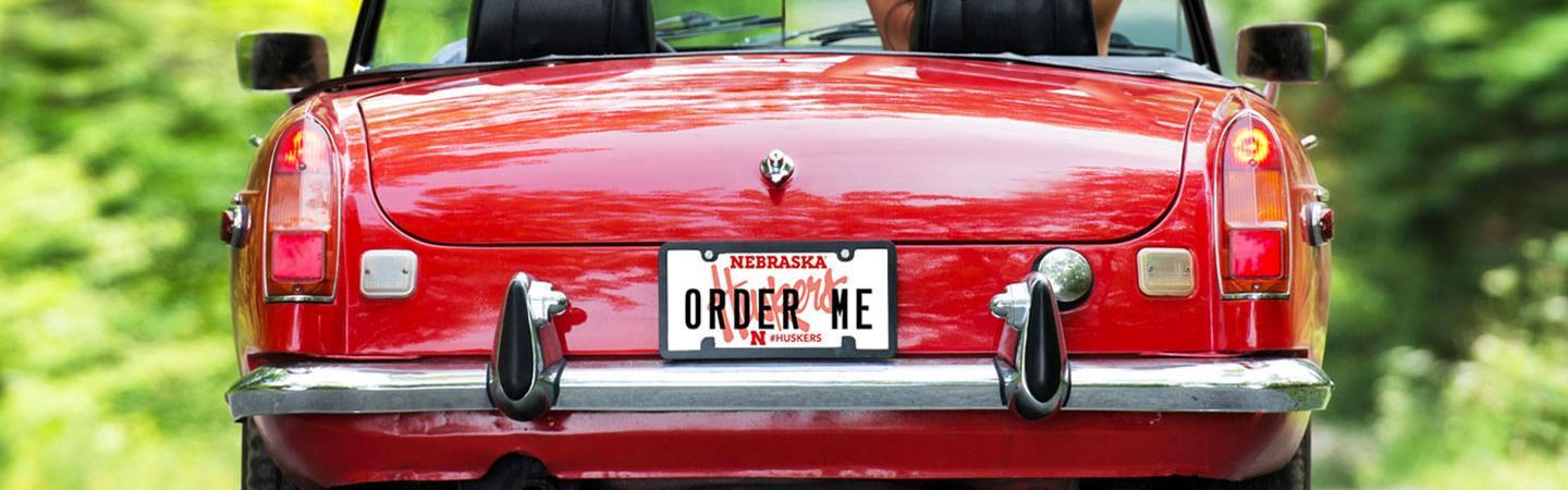 back of shiny red car with a custom Husker license plate that says "ORDER ME"