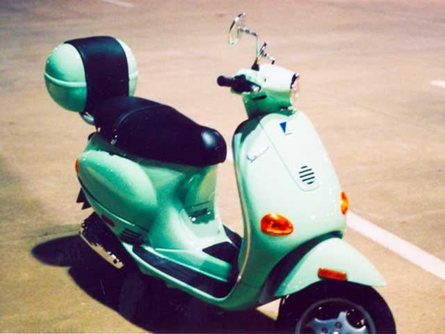 front of green vespa in parking lot